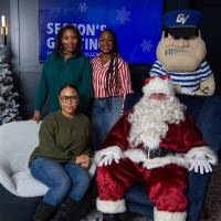 Three women pose with Santa and Louie